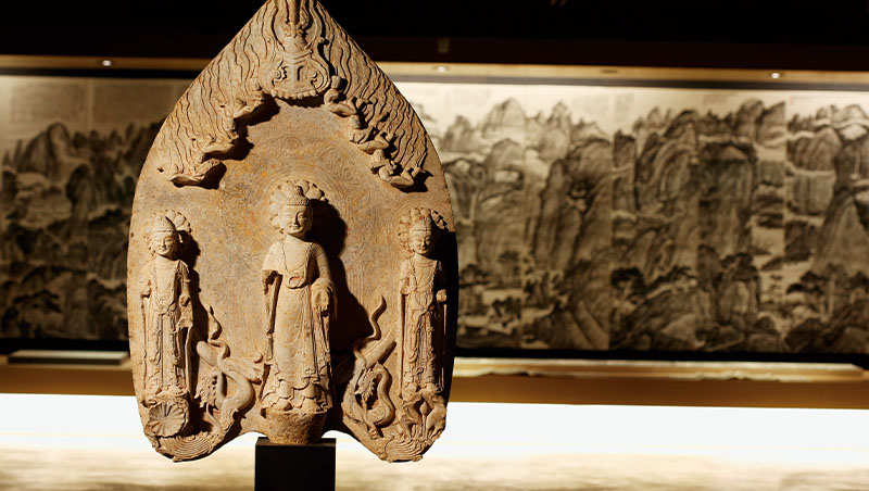 來自東魏時期的佛三尊造像碑放於入口處，背後是書畫家張光屏的山水十二聯屏，讓人一進門就能感受到地下宮殿的氣派。（攝影：駱裕隆）