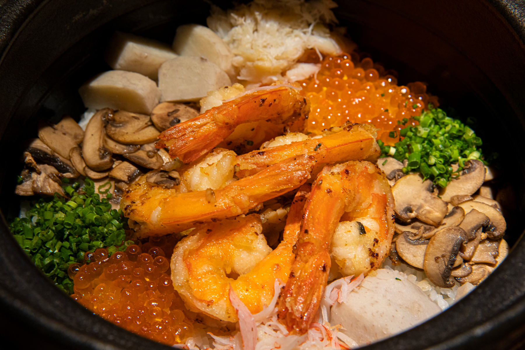 將大蝦、鮭魚卵等鋪蓋在炊熟米飯上，營造豐盛澎湃的視、味覺感受。（攝影／郭涵羚）