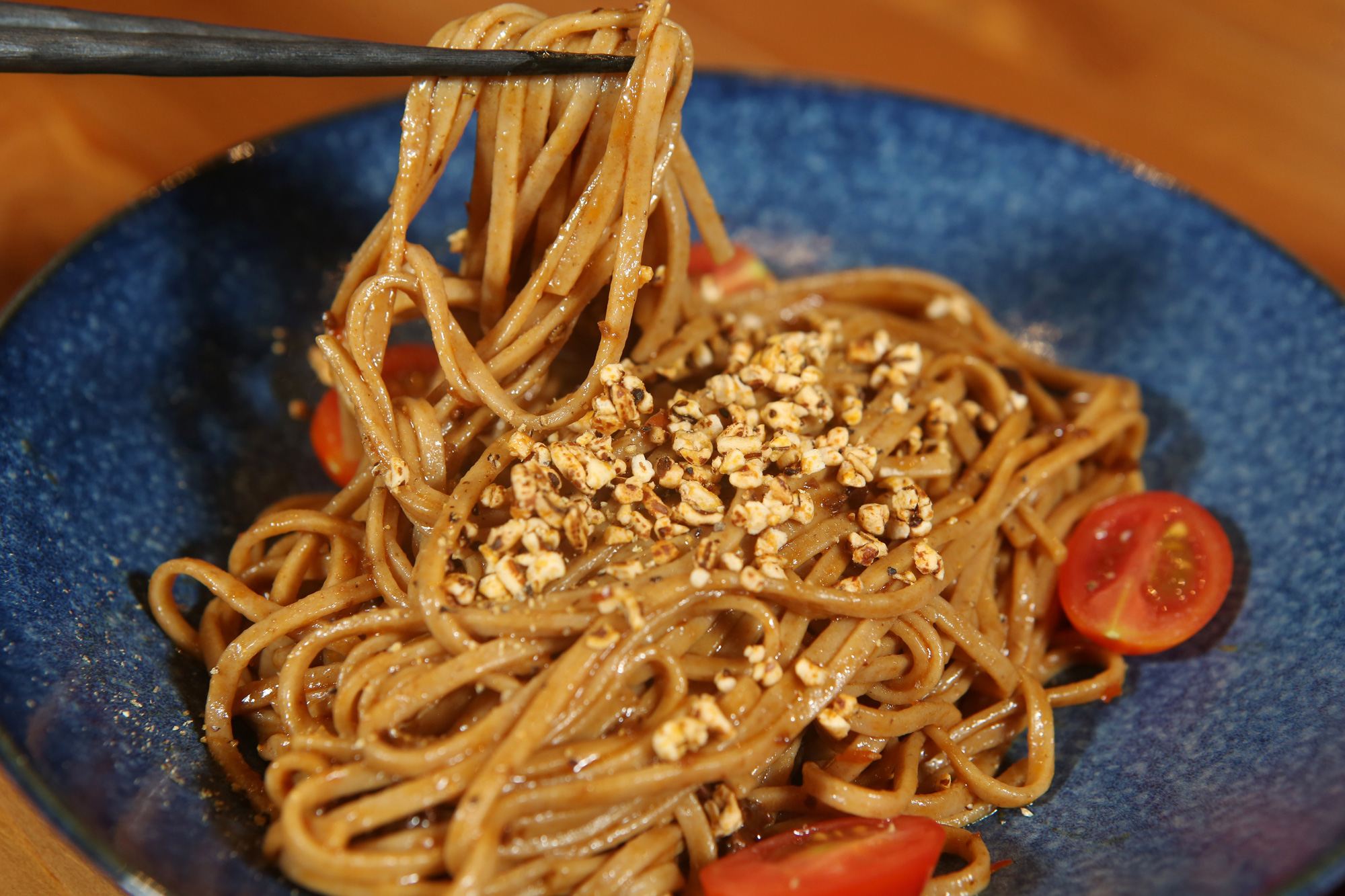 台灣小麥麵條口感滑嫩，拌上香鹹醬汁，撒上小麥塊碎片，增添多變口感。（攝影／駱裕隆）