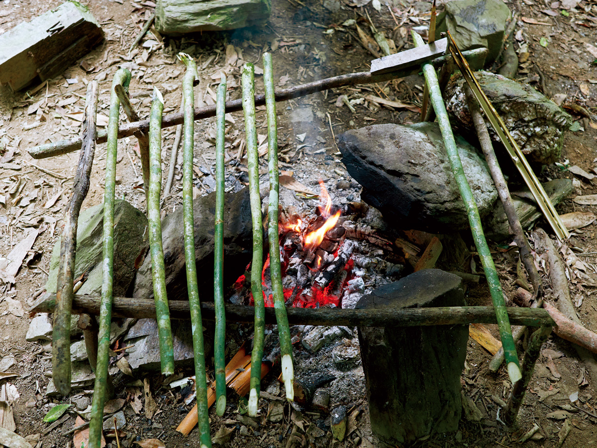 三石灶上鋪排著旁邊砍下來的樹枝，成了天然烤肉架。（攝影／王文廷）
