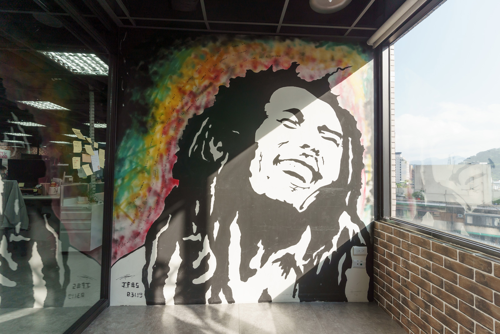 在foodpanda位於7樓的工業風辦公室，4間會議室壁畫全出自方俊強之手。他看YouTube自學塗鴉，週末獨自彩繪辦公室，一幅甚至畫上8小時。圖中這幅是向雷鬼樂之父巴布・馬利（Bob Marley）致敬，隔壁間還有佛祖「女神」、外太空的鋼鐵人壁畫，像一場穿越時空藝術小旅行。（攝影／陳鴻文）