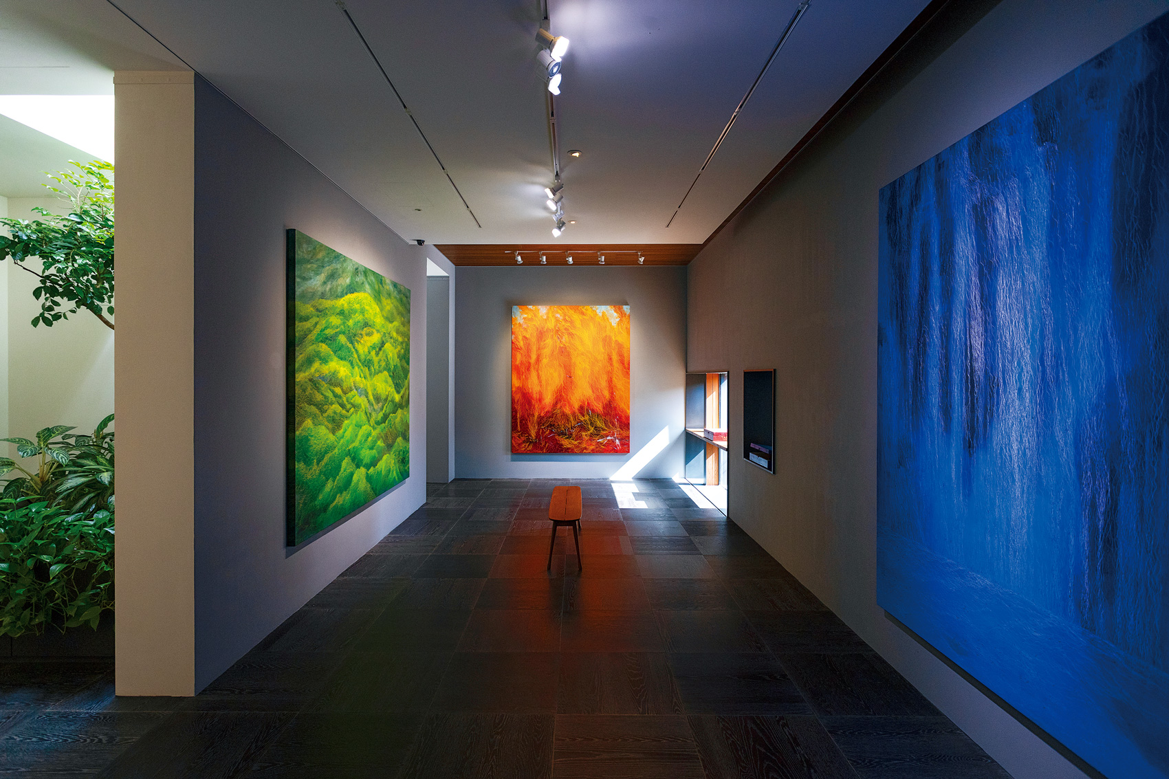鄭麗雲最新個展中展出她最經典的「地、氣、水、火」系列，在光影照耀下，顯得格外氣派生動。（攝影／劉煜仕）
