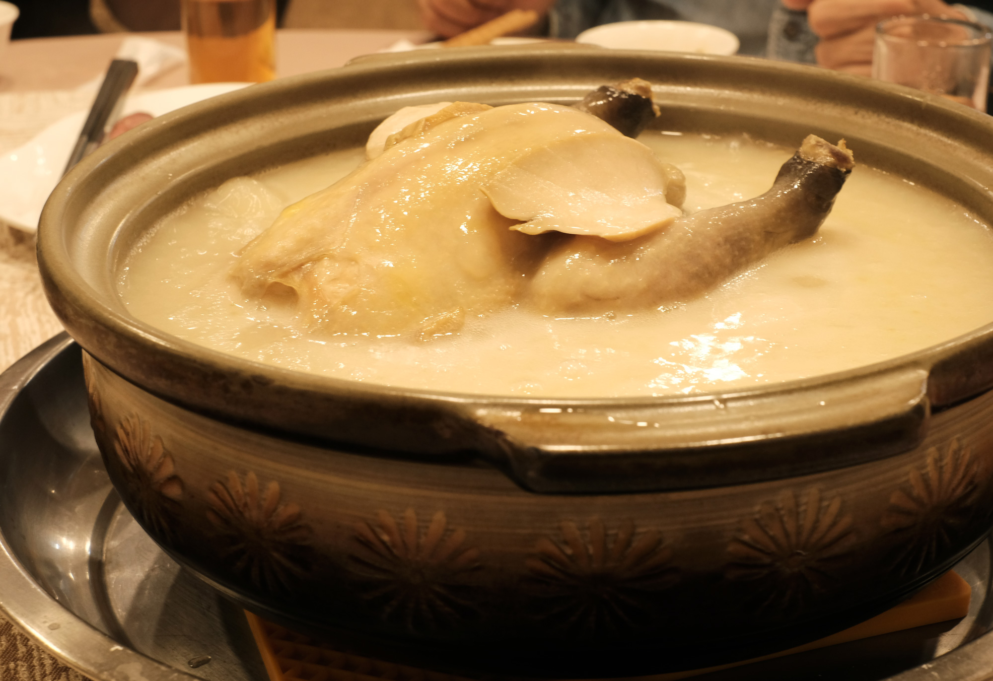 「明福台菜」的鮑魚糯米雞，雞汁與糯米在砂鍋中長時間熬燉，已融作一氣。（圖片來源／洪愛珠）