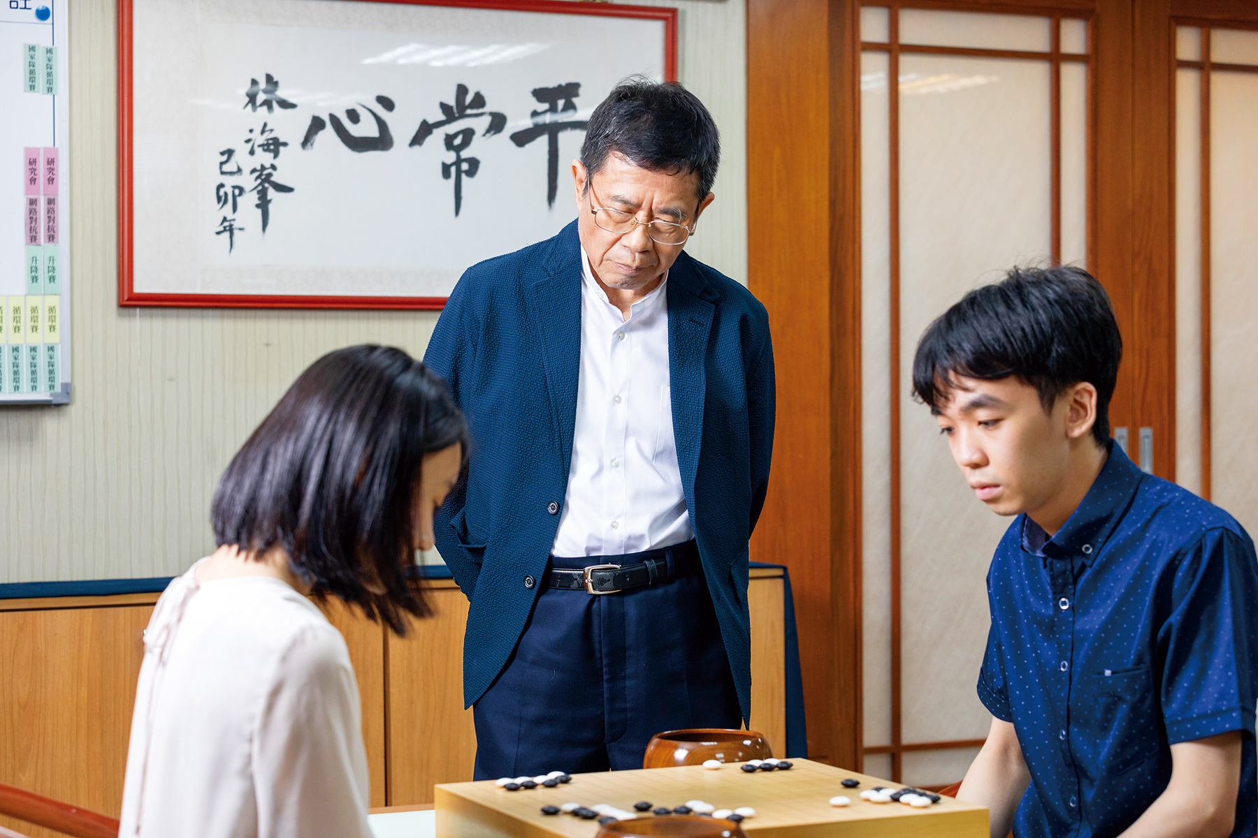 林文伯在海峰棋院內時不時關心棋士們的棋藝進展，背後懸掛的「平常心」三字是國手林海峰親筆字跡，也是林文伯希望棋士們能做到的最高境界。（攝影／劉煜仕）