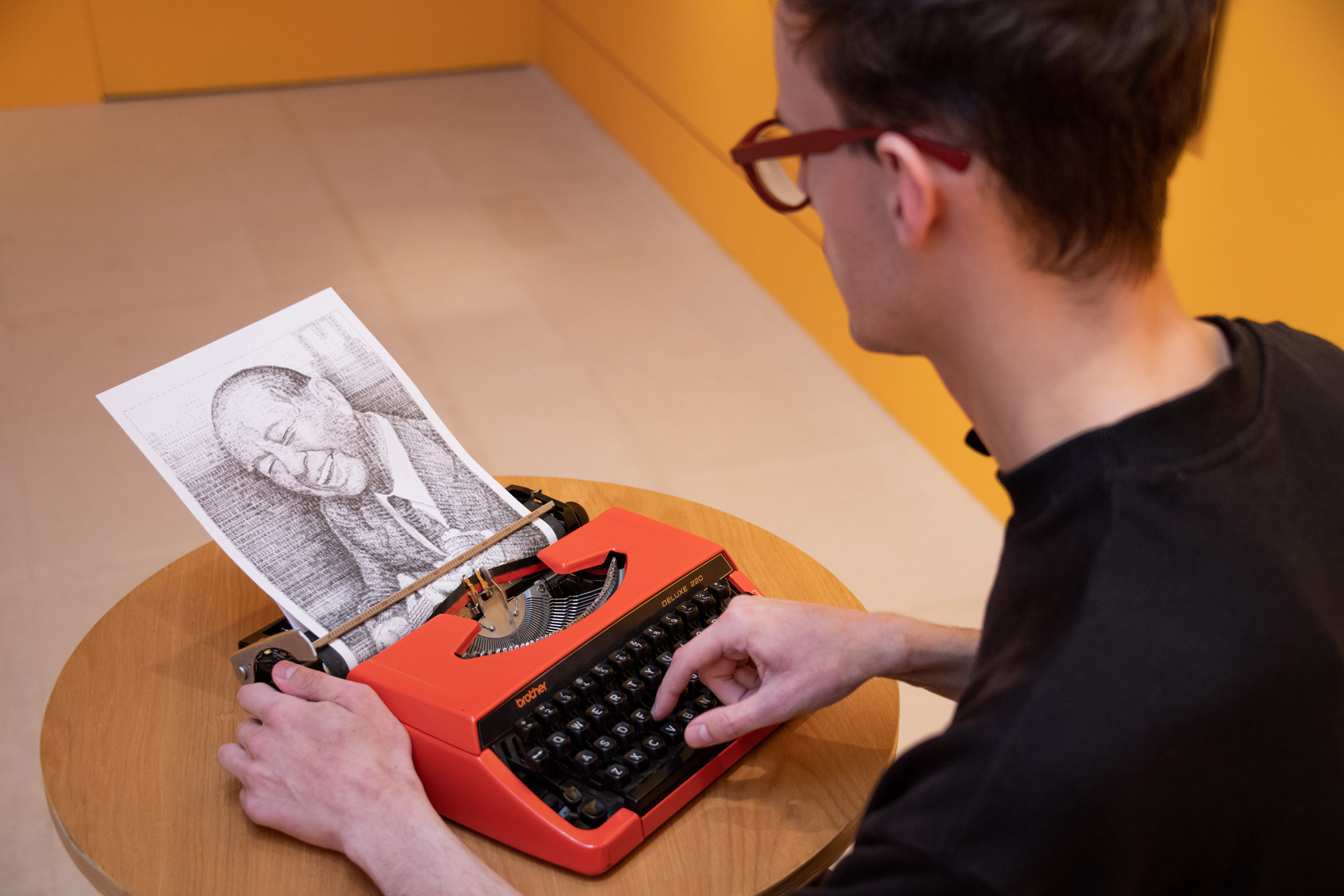 「跳出格子吧！」特展「機器超展開」打字機展區，用打字機畫畫，藝術家庫克現場創作奇美創辦人許文龍的肖像畫。（圖片來源／奇美博物館）