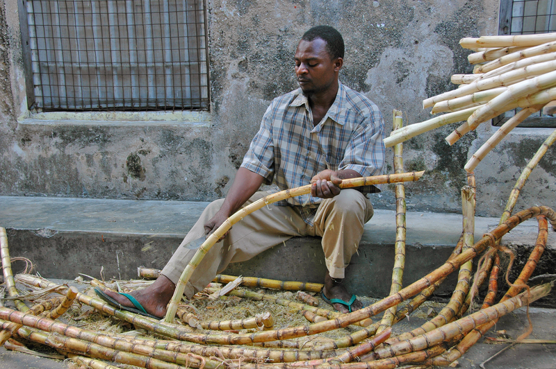 在非洲坦尚尼亞尚吉巴街頭切割甘蔗的工人。（圖片來源／dreamstime）