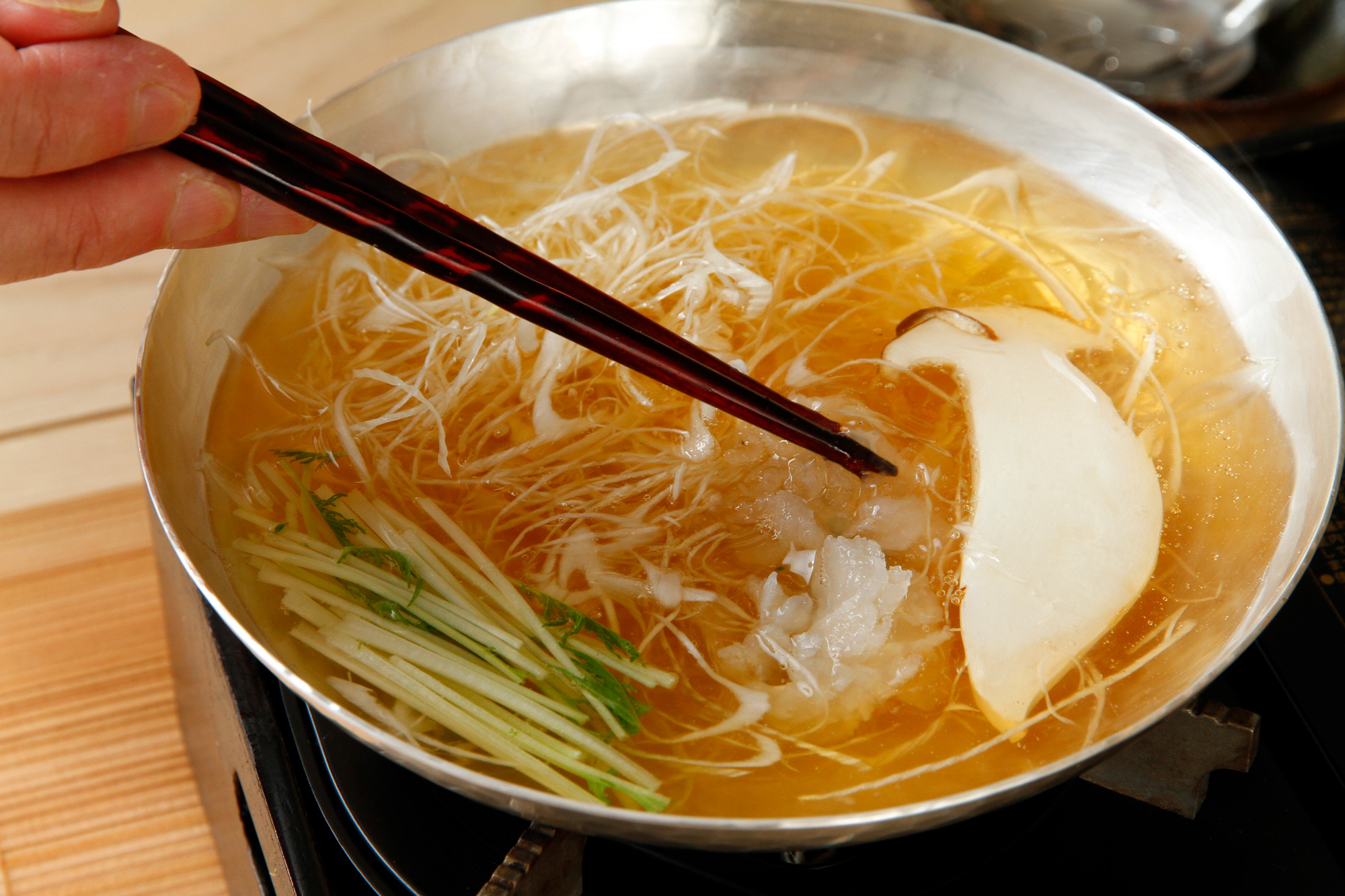 每一碗高湯都是神田根據客人吃飯的速度，要喝時才開始煮；現削的柴魚片放進昆布高湯，30秒即得撈出。（攝影：呂恩賜）