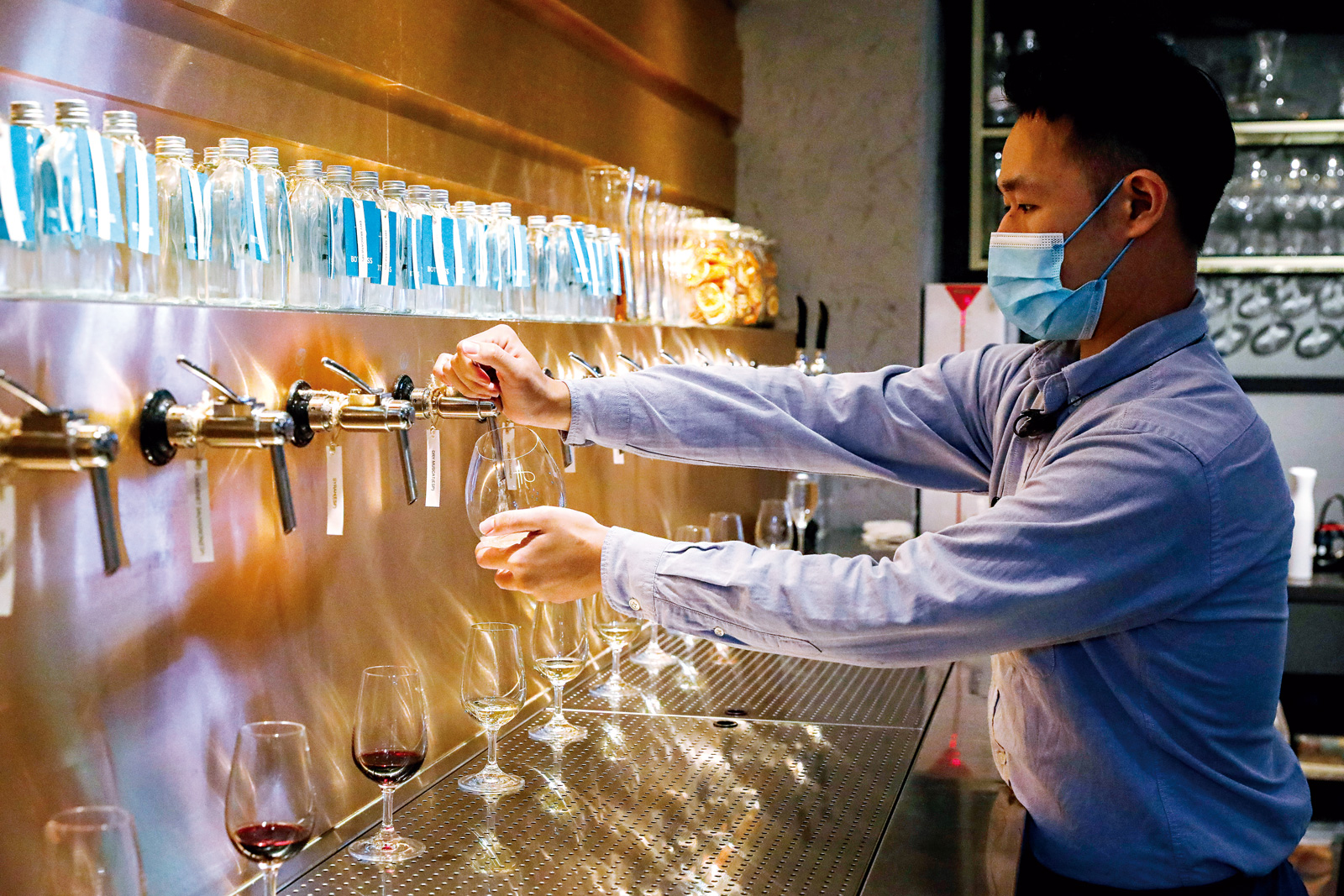 酒吧牆面上的出酒籠頭,有各式葡萄酒任員工暢飲。(攝影:陳宗怡)