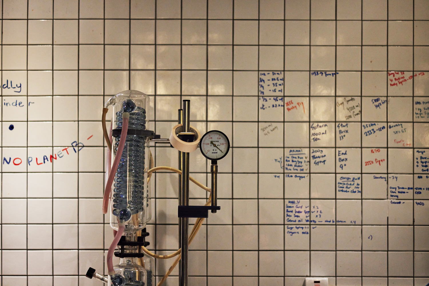 Penicillin的入口放了一座科學儀器，瓶瓶罐罐，白瓷磚牆上寫滿數字，像在解數學公式，不像酒吧，反倒像是高中科學教室。（攝影：石吉弘）
