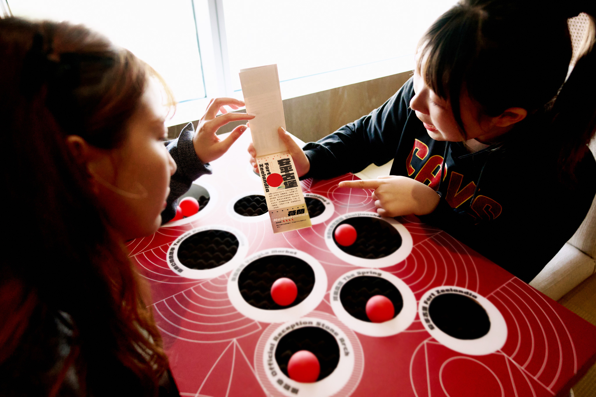 「紅球跳」設計在榻榻米上，將紅色乒乓球以彈地的方式入洞的趣味遊戲。（圖片來源：台南晶英提供）