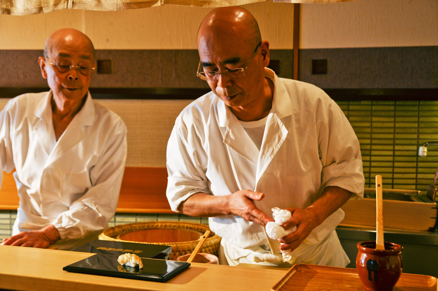 數寄屋橋次郎壽司主廚小野二郎（左）與小野二郎的兒子小野禎一（右）在板前捏製握壽司。（攝影：李明宜）