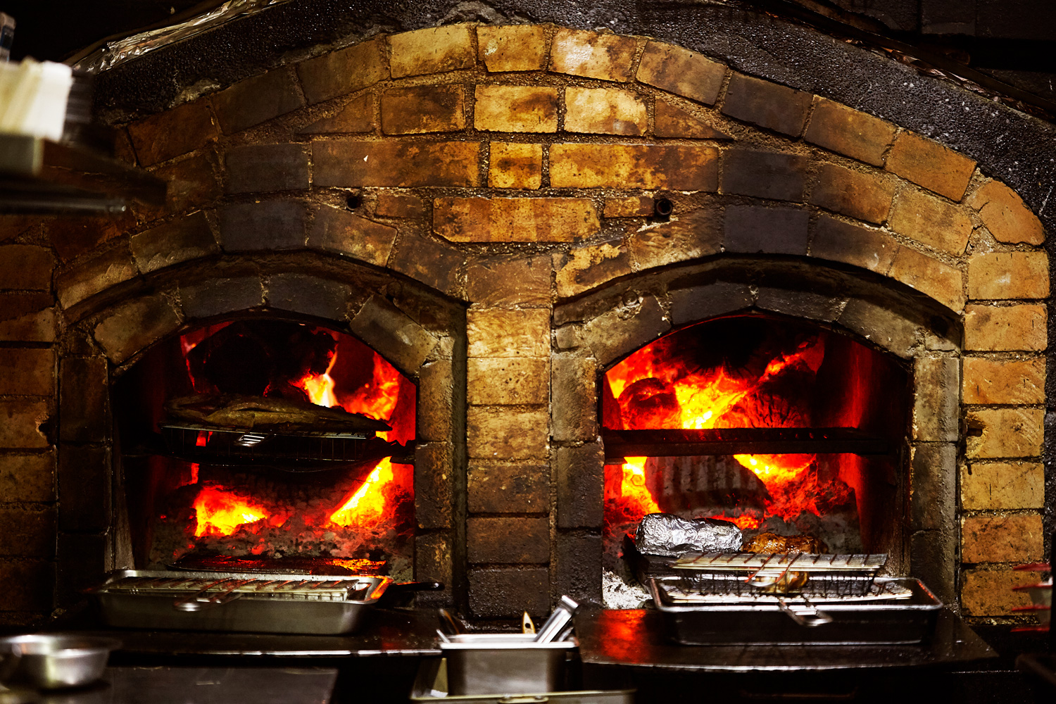 店名AKAME是魯凱族語燒烤之意，料理以火烤為主。餐廳門口兩個大烤爐，是工匠老爸為他砌的。（攝影：王文廷）