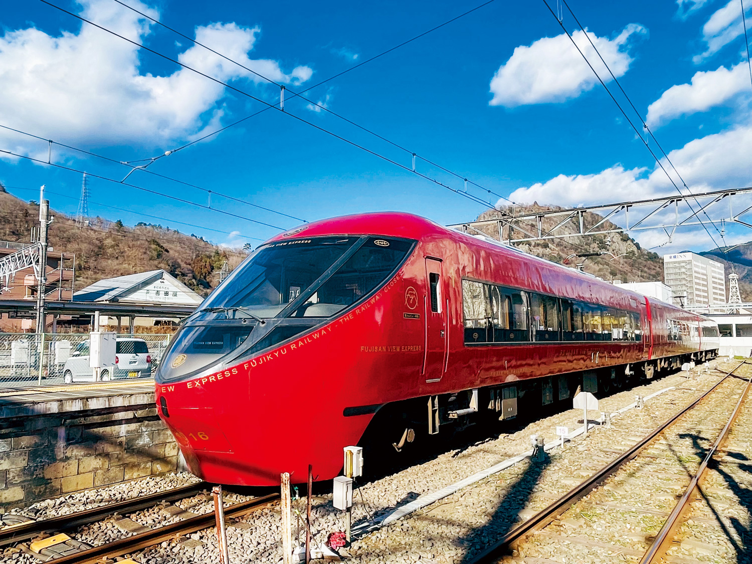 富士急甜點列車是一台景觀列車，車廂上有一個類似武士家徽的標誌，標誌內就是一座富士山。酒紅色車體非常醒目。（圖片來源：李清志提供）