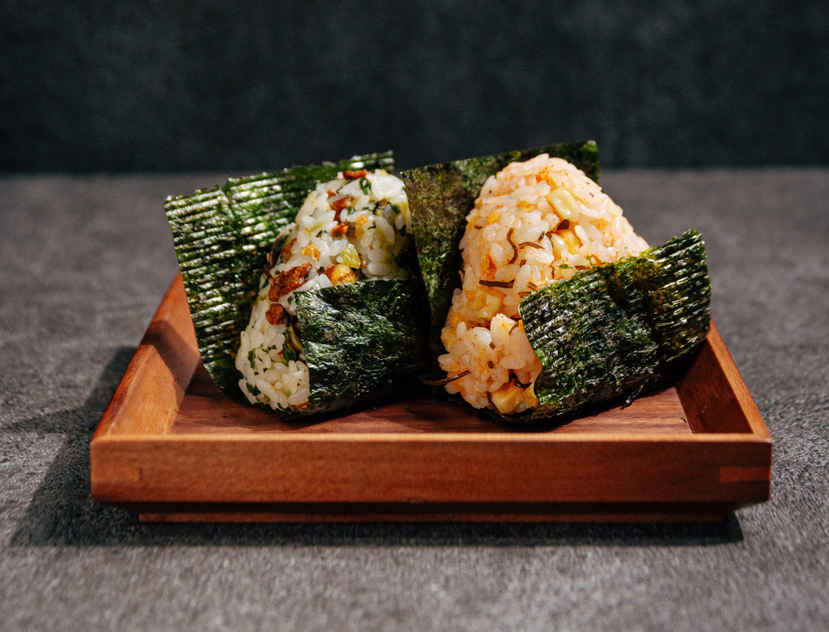 手作飯糰共有狸貓口味（炸玉米天婦羅、昆布絲、芝麻油）和老上海菜飯（靑江菜、柳松菇、蛋酥、靑辣椒）等兩種口味。（圖片來源：小小樹食提供）