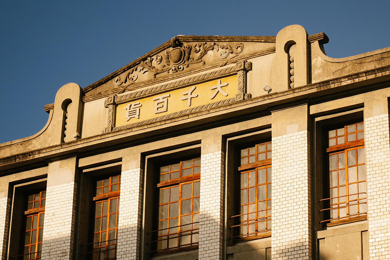 從建築頂樓山牆上，飾有浮雕和花飾的古早招牌，可窺見當年風光。（圖片來源：PILLO提供）