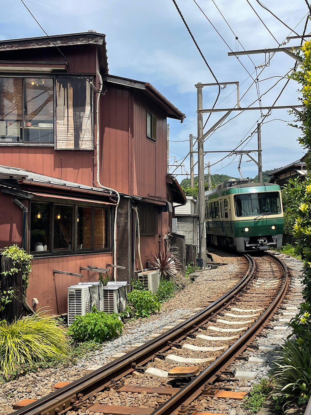 江之電電車與這附近民宅與鐵道的距離很近，有些住家大門必須穿越鐵軌才能到達。（圖片來源：大塊文化提供）