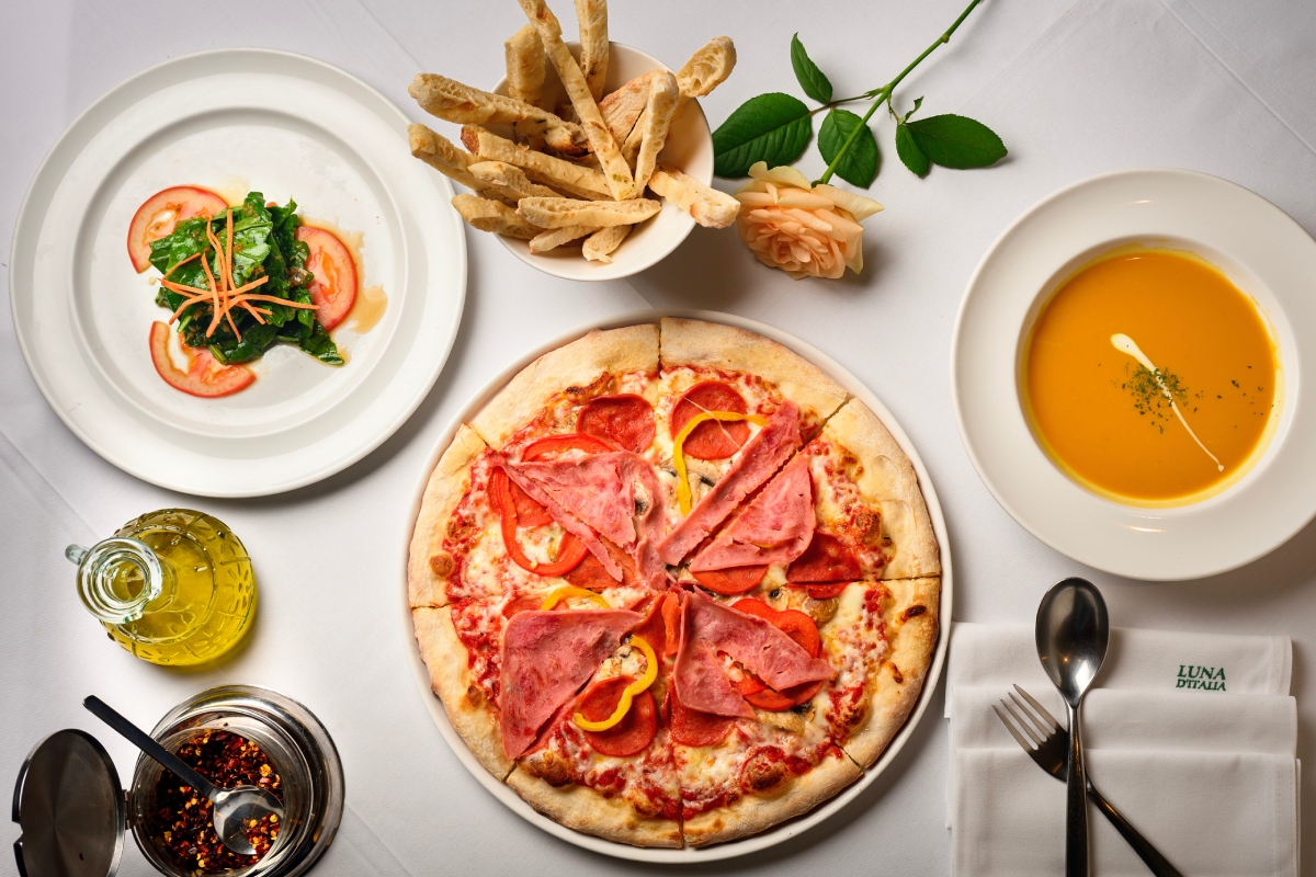 「主廚披薩」，蕃茄醬底結合燻雞、香腸、菠菜與蛋黃，堆疊出濃厚又俐落的經典風味。