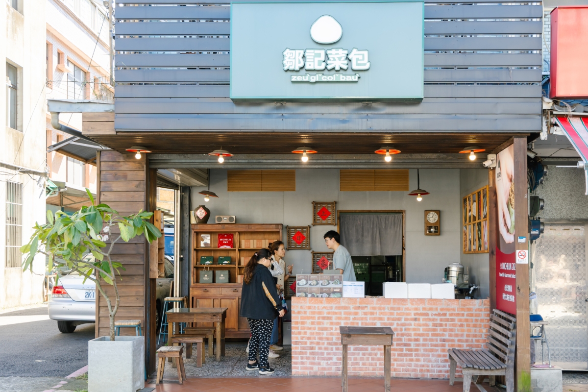 鄒記菜包店面乾淨明亮，帶著年輕人特有的簡潔設計感：灰牆、紅磚、木造櫃。